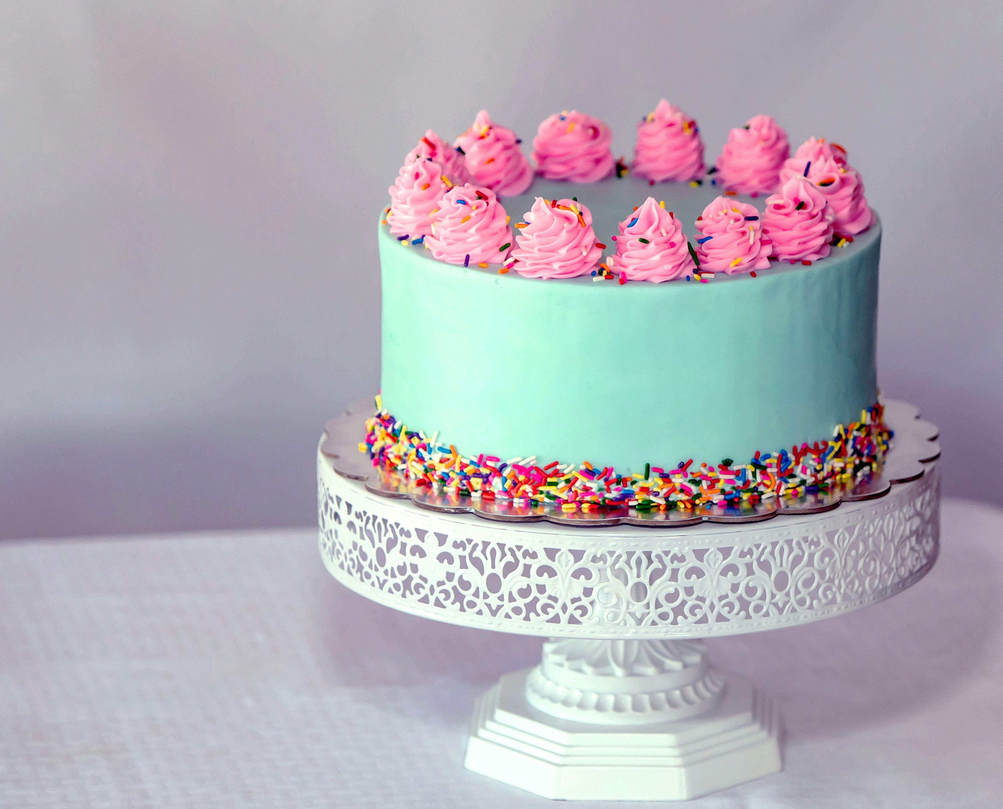A pink and blue celebration cake with piped flowers